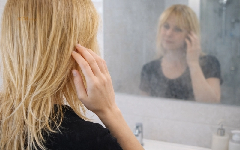 Une femme portant une perruque synthétique dans une salle de bain après une exposition à la vapeur de douche Une femme portant une perruque synthétique dans une salle de bain après une exposition à la vapeur de douche